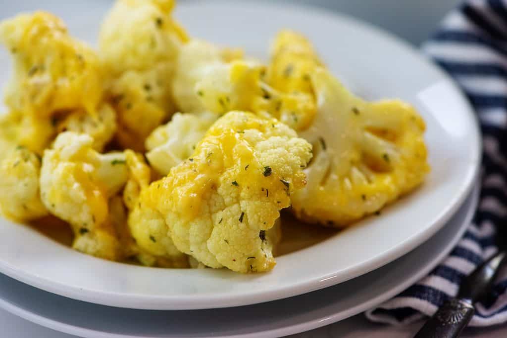 baked cauliflower on white plate covered in cheese