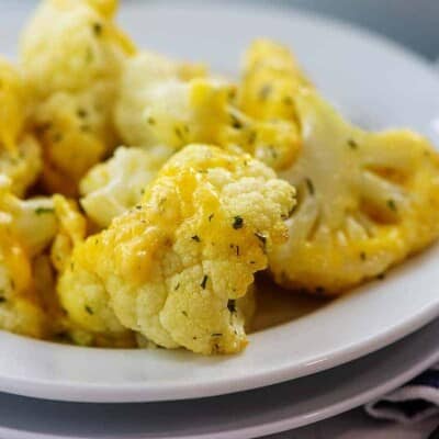 baked cauliflower on white plate covered in cheese