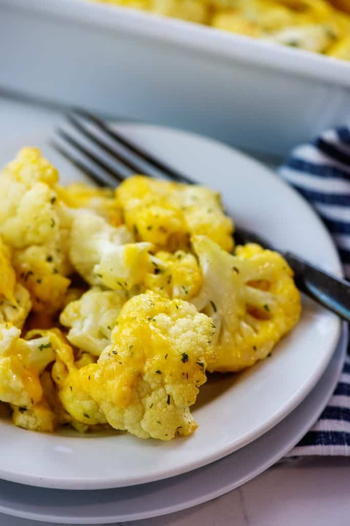 baked cauliflower covered in cheese on white plate