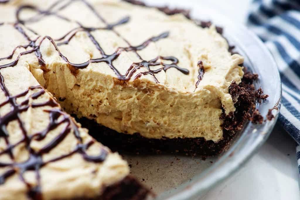 creamy low carb peanut butter pie in pie dish with chocolate drizzled on top