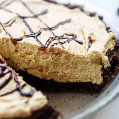 creamy low carb peanut butter pie in pie dish with chocolate drizzled on top