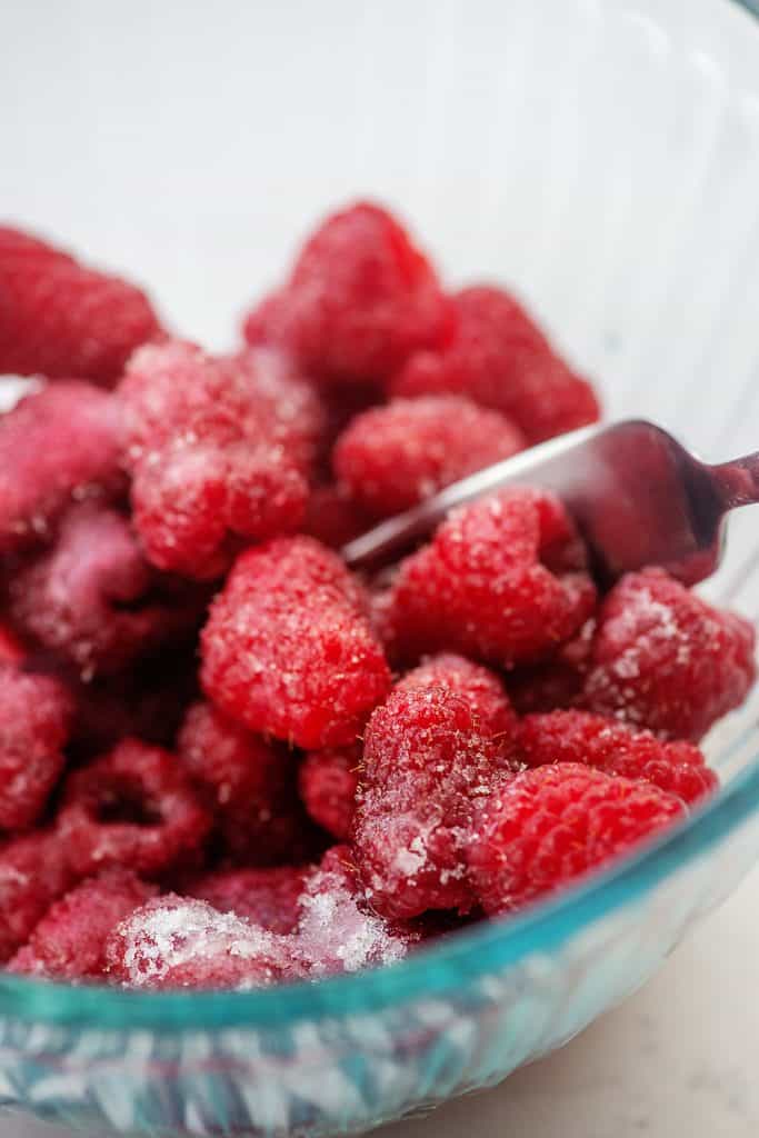 fresh raspberries in bowl with lemon juice and sweetener