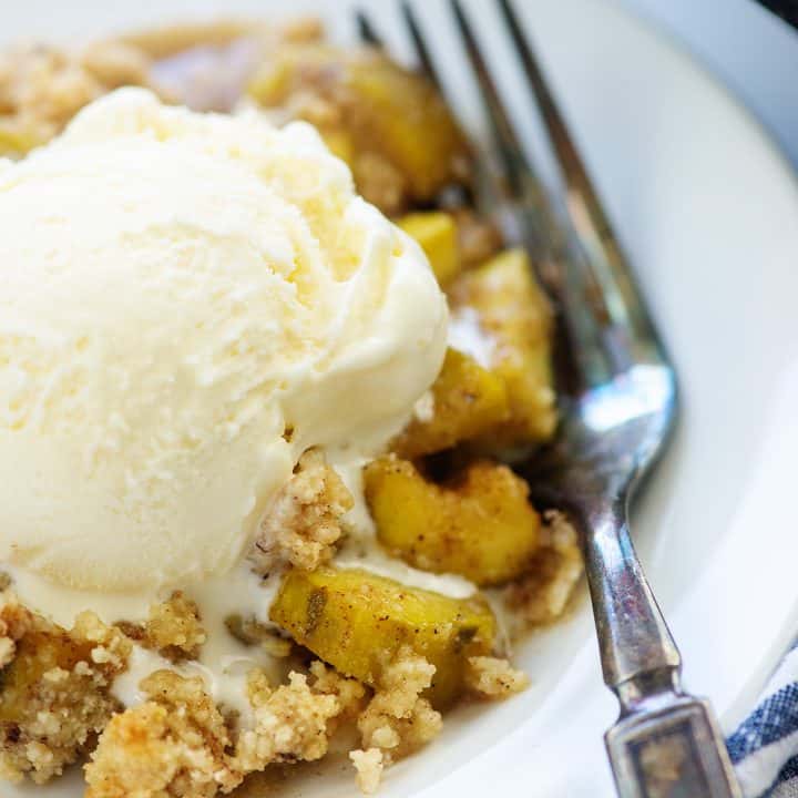 zucchini cobbler on white plate with ice cream on top