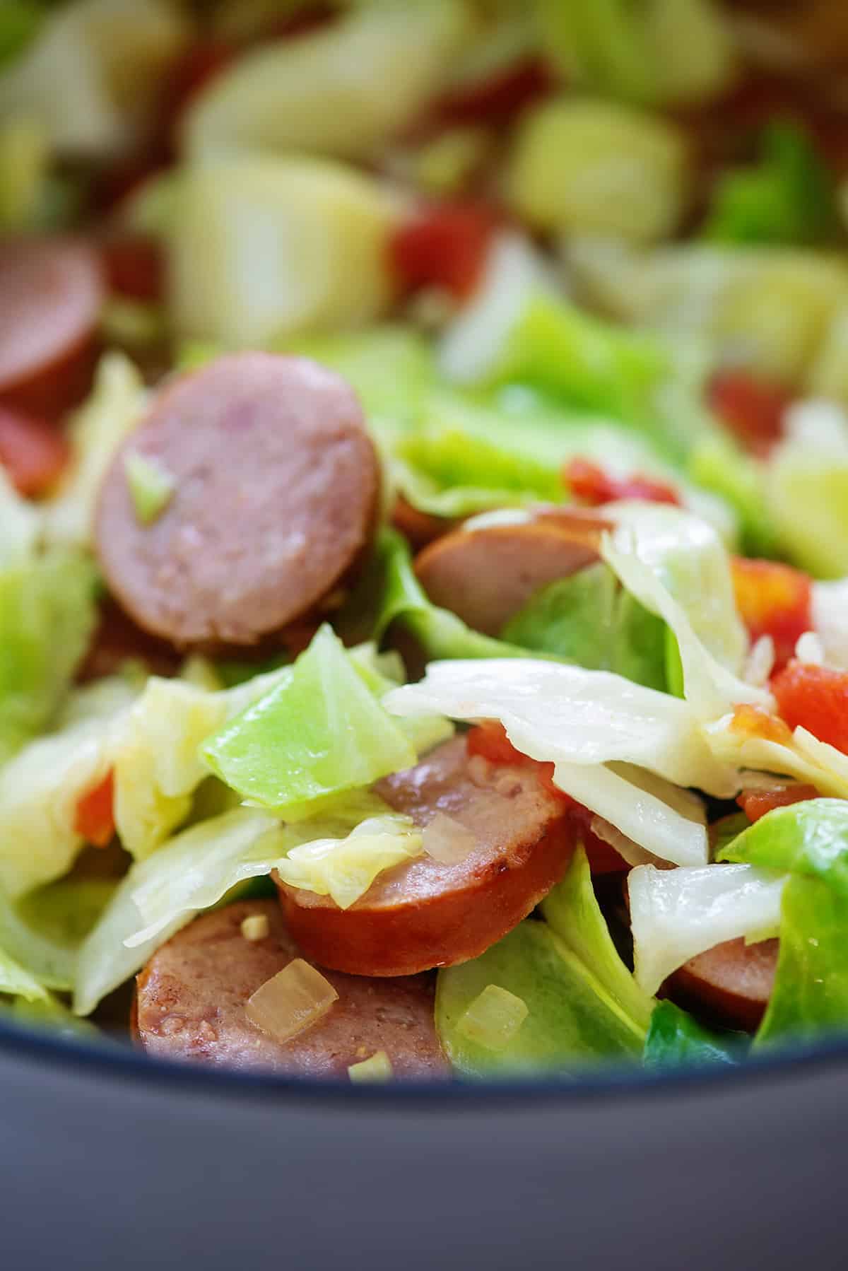 cabbage, sausage, and diced tomatoes in soup pot