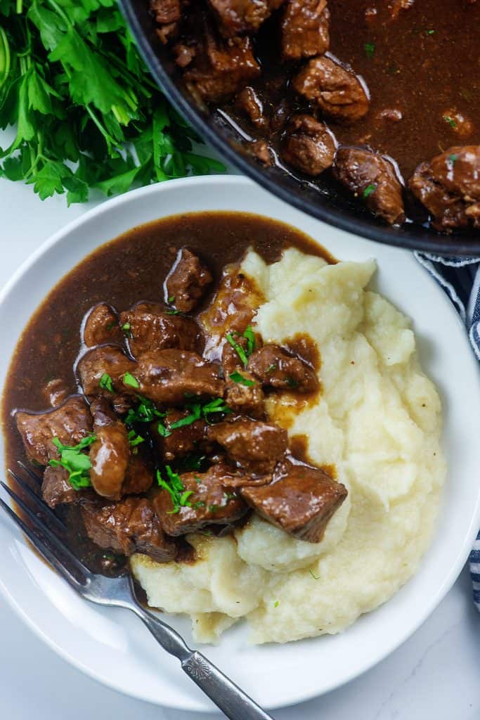 beef tips and mashed cauliflower on white plate