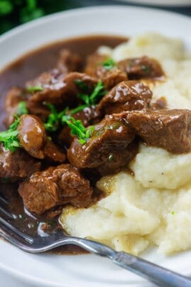 cauliflower and beef with gravy on white plate
