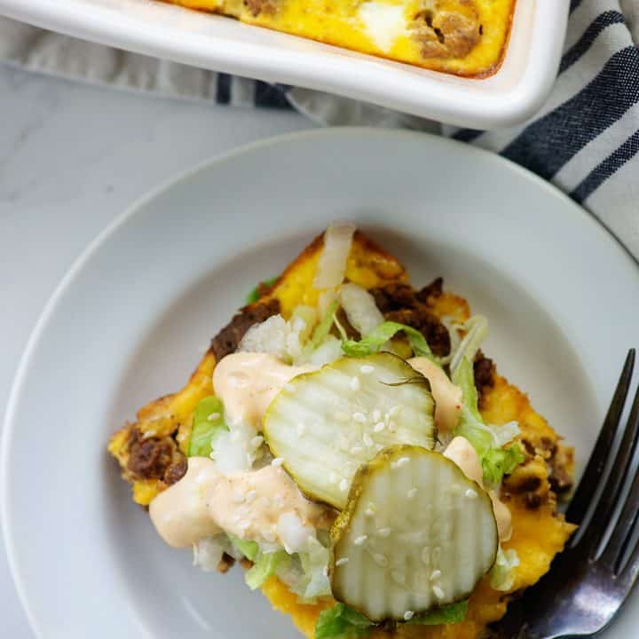 big mac casserole on white plate topped with pickles and special sauce