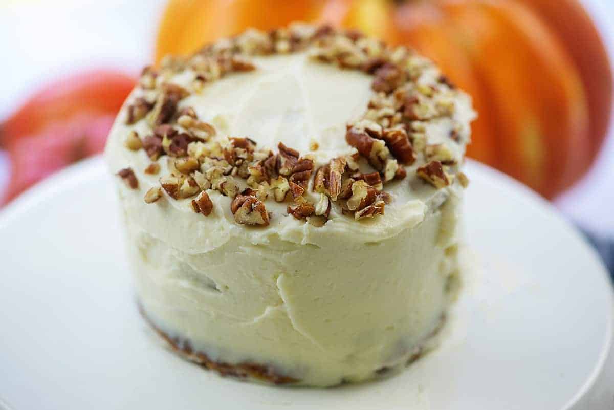 mini keto pumpkin layer cake with cream cheese frosting on cake stand
