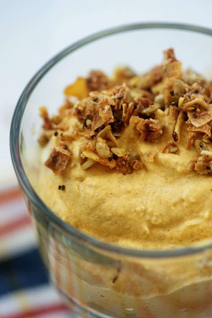 creamy pumpkin mousse in glass dish topped with granola