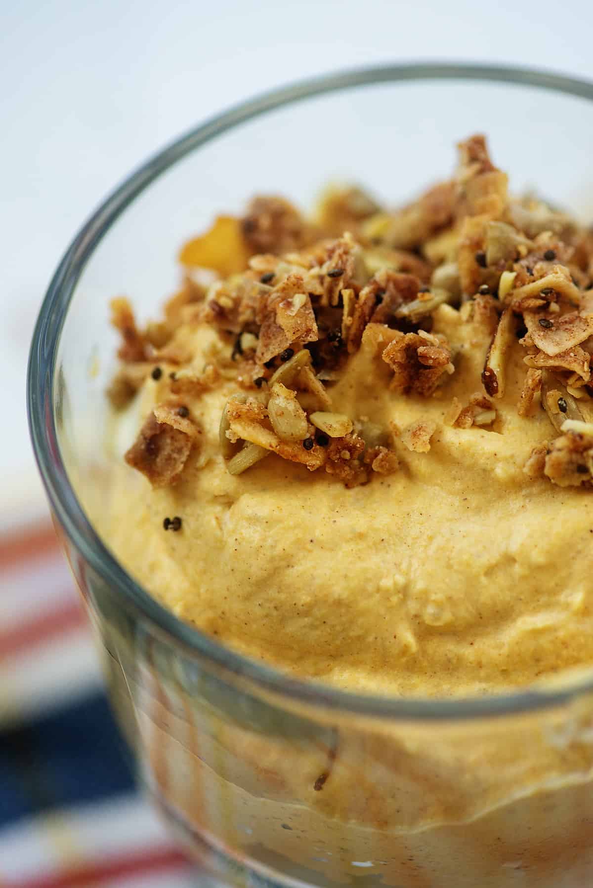 creamy pumpkin mousse in glass dish topped with granola