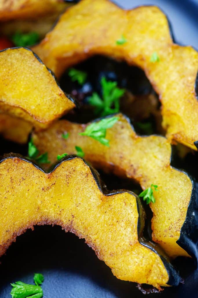 sliced acorn squash on black plate