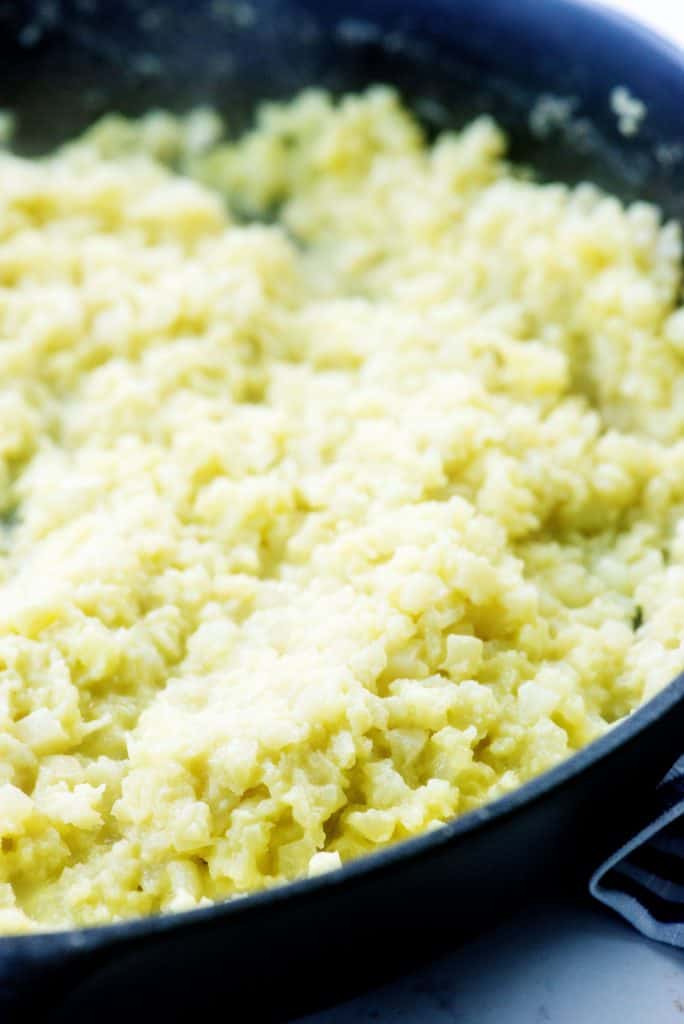 cooked cauliflower in cast iron black skillet.