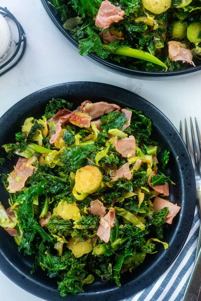 black plate full of kale and brussels sprouts