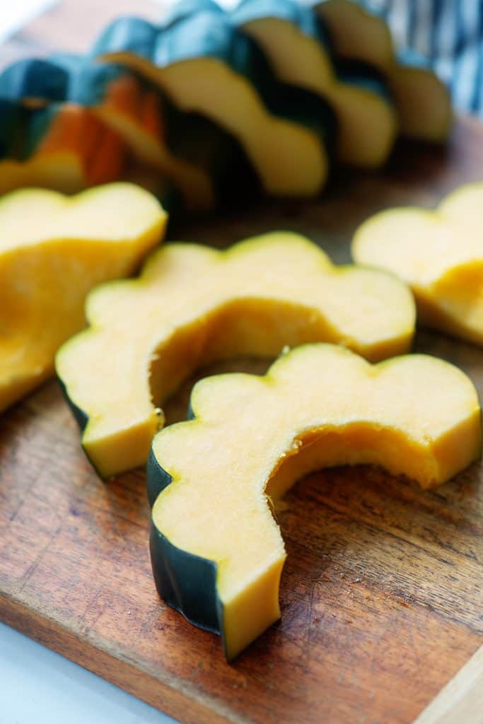 sliced acorn squash on wooden cutting board