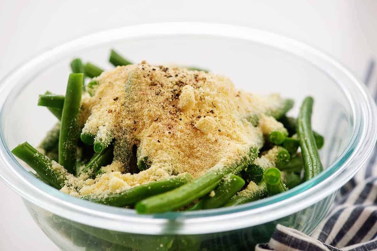 green beans and Parmesan cheese in glass mixing bowl.
