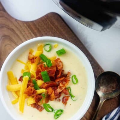 cheesy cauliflower soup recipe in white bowl.