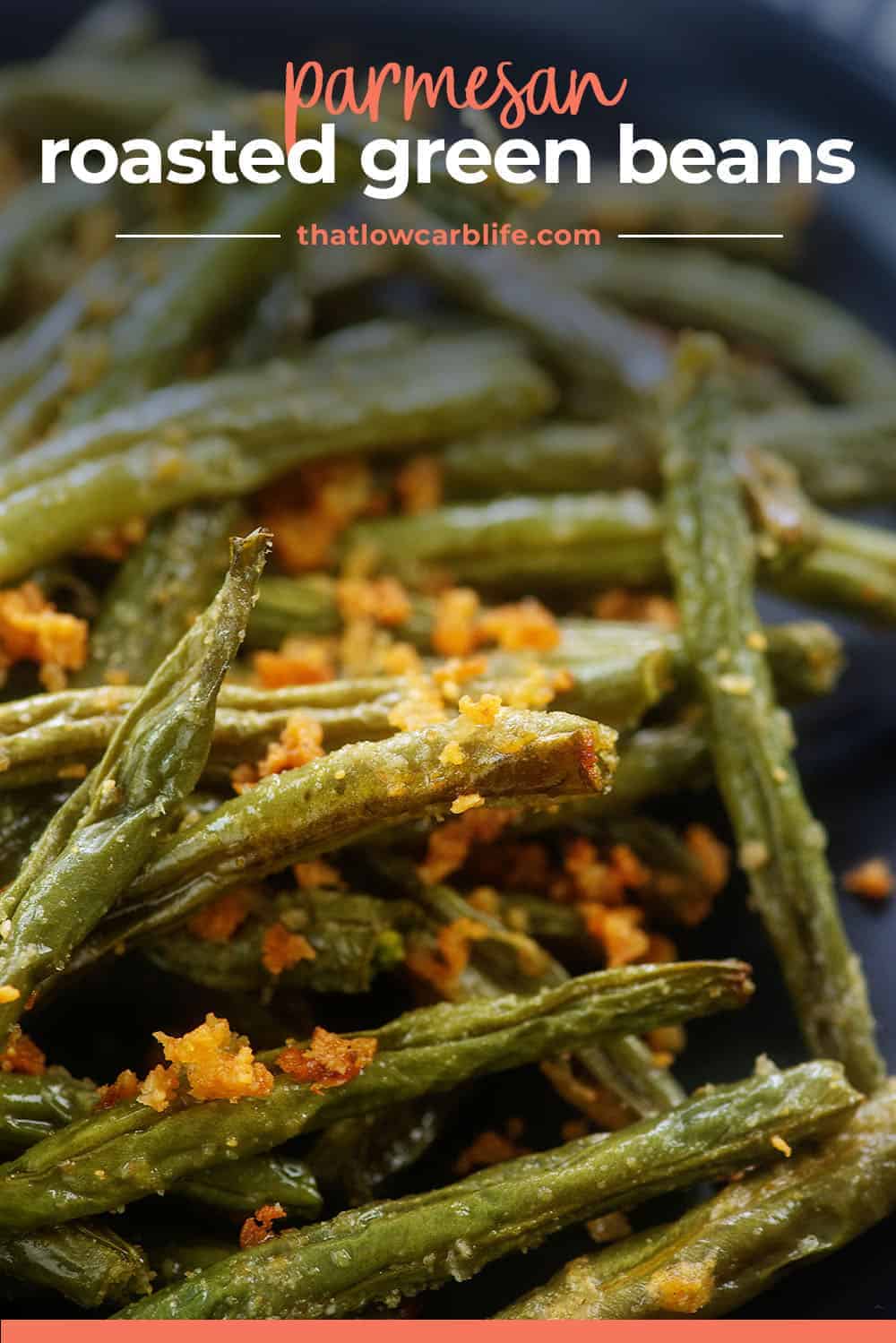 pile of roasted green beans on black plate.