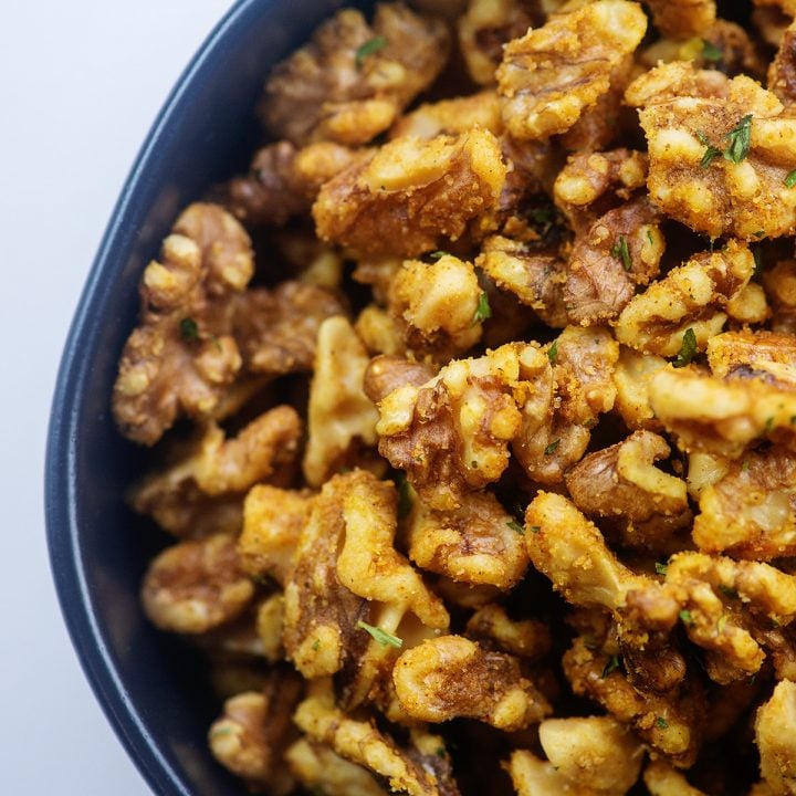 roasted walnuts in black bowl.