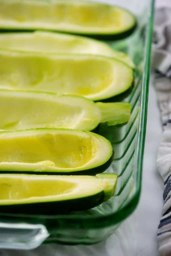 hollowed out zucchini in glass dish.