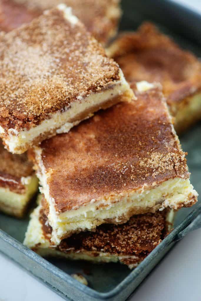 keto snickerdoodle cheesecake bars piled in metal dish.