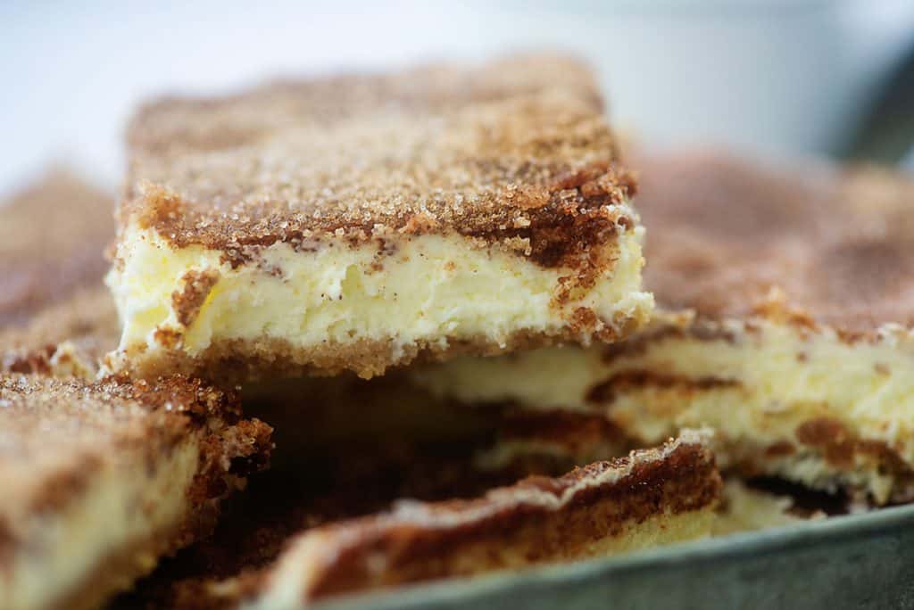 keto cheesecake bars piled in metal dish.