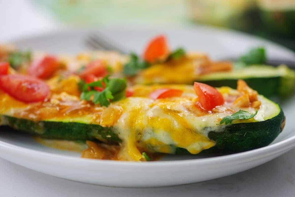 cheesy enchilada zucchini boats on white plate.