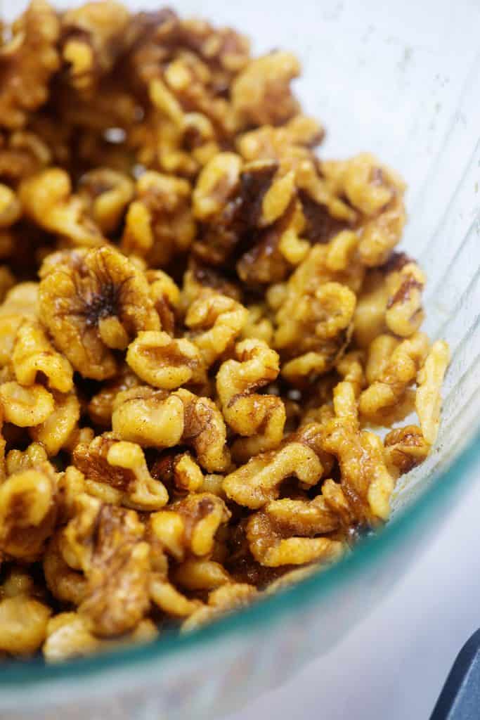 seasoned walnuts in glass mixing  bowl.