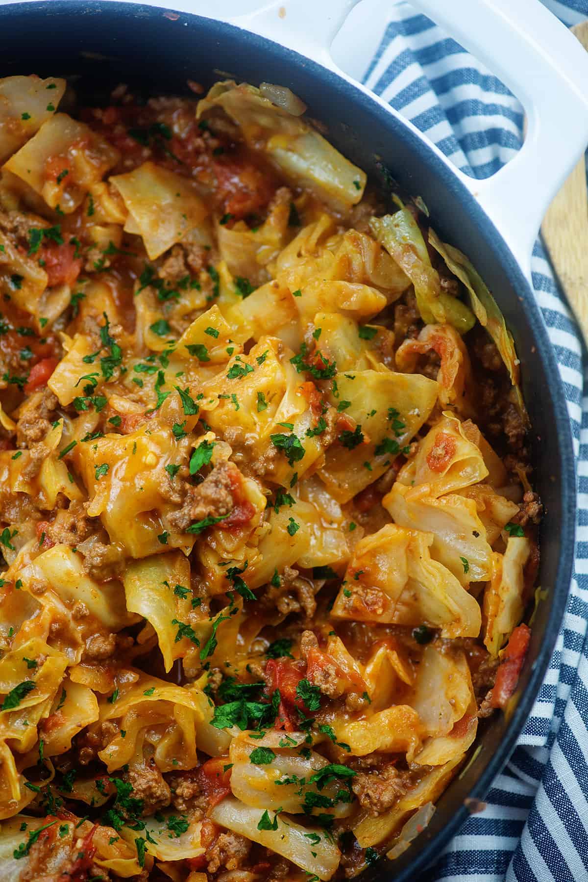 overhead view of cheesy cabbage casserole in white pot.