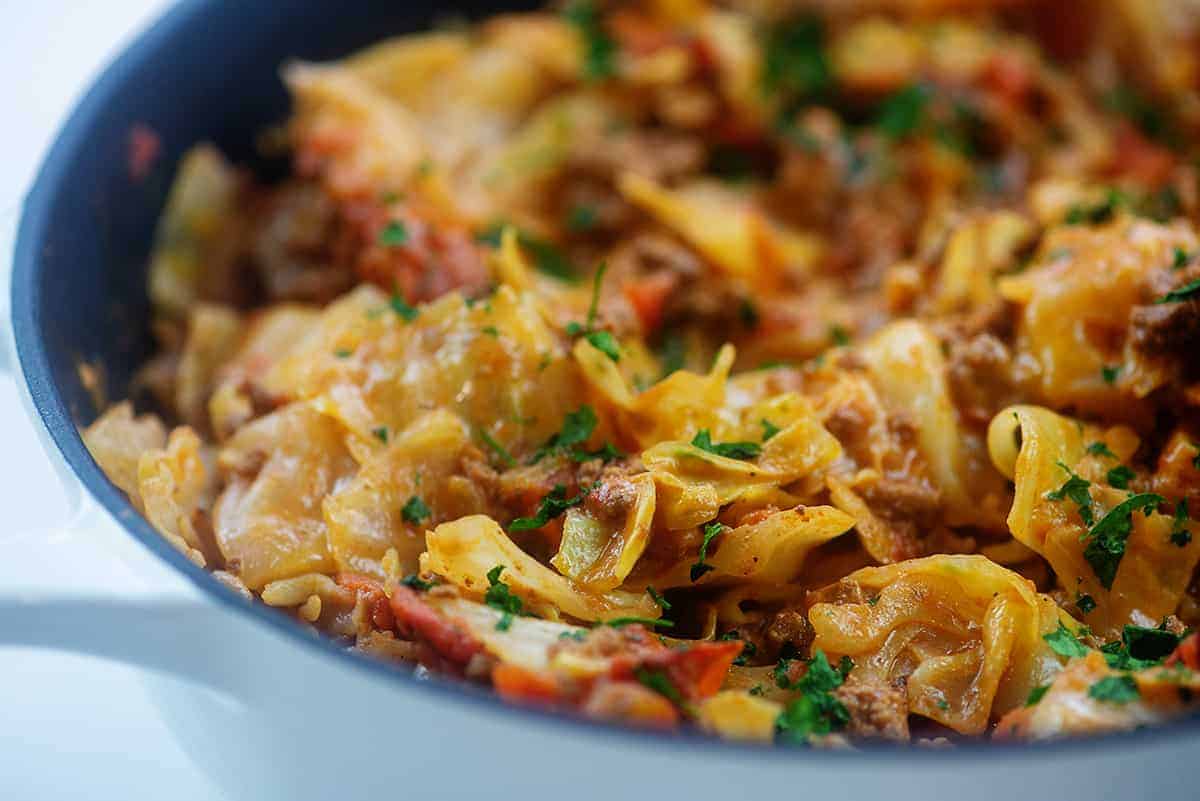 cheesy cabbage and beef in white skillet.