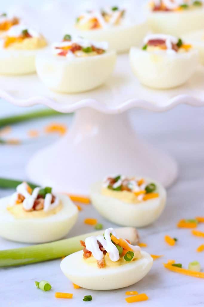deviled eggs topped with sour cream and bacon.