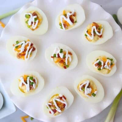 overhead view of keto deviled eggs topped with cheddar, bacon, and sour cream.