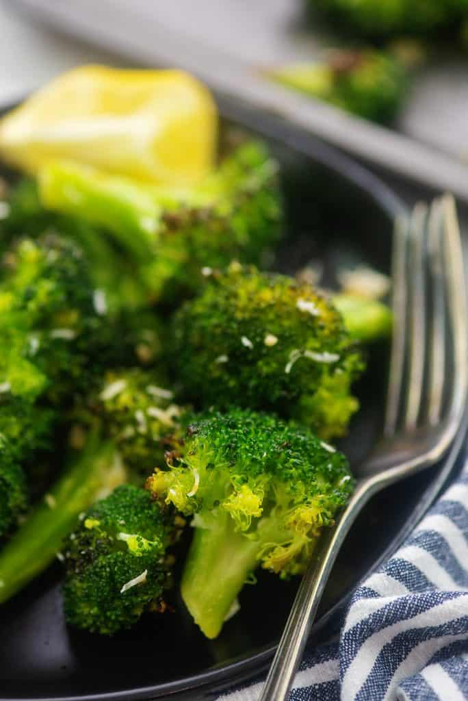 roasted broccoli on black plate.