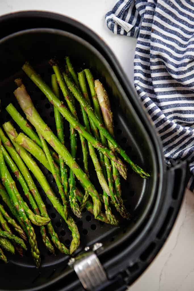 overhead view of asparagus in air fryer basket.