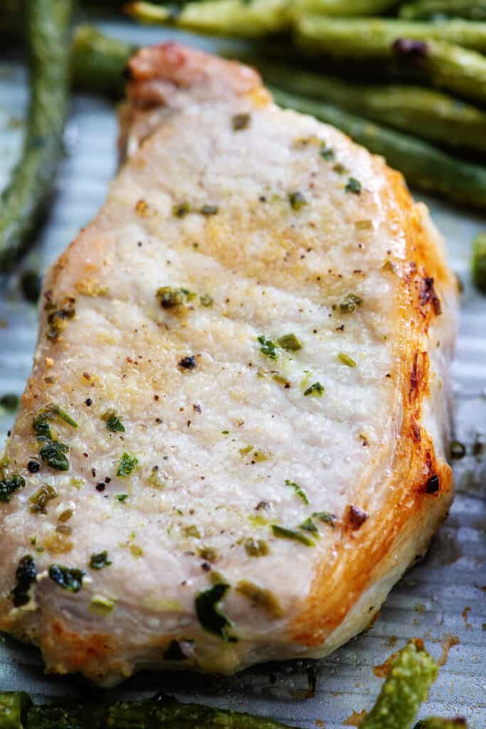 close up view of baked ranch pork chop on sheet pan.