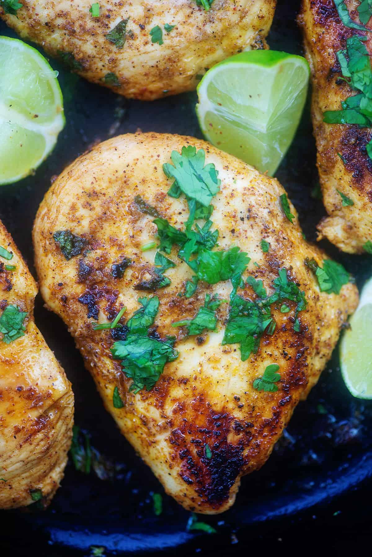 overhead view of cilantro lime chicken breasts in cast iron skillet.