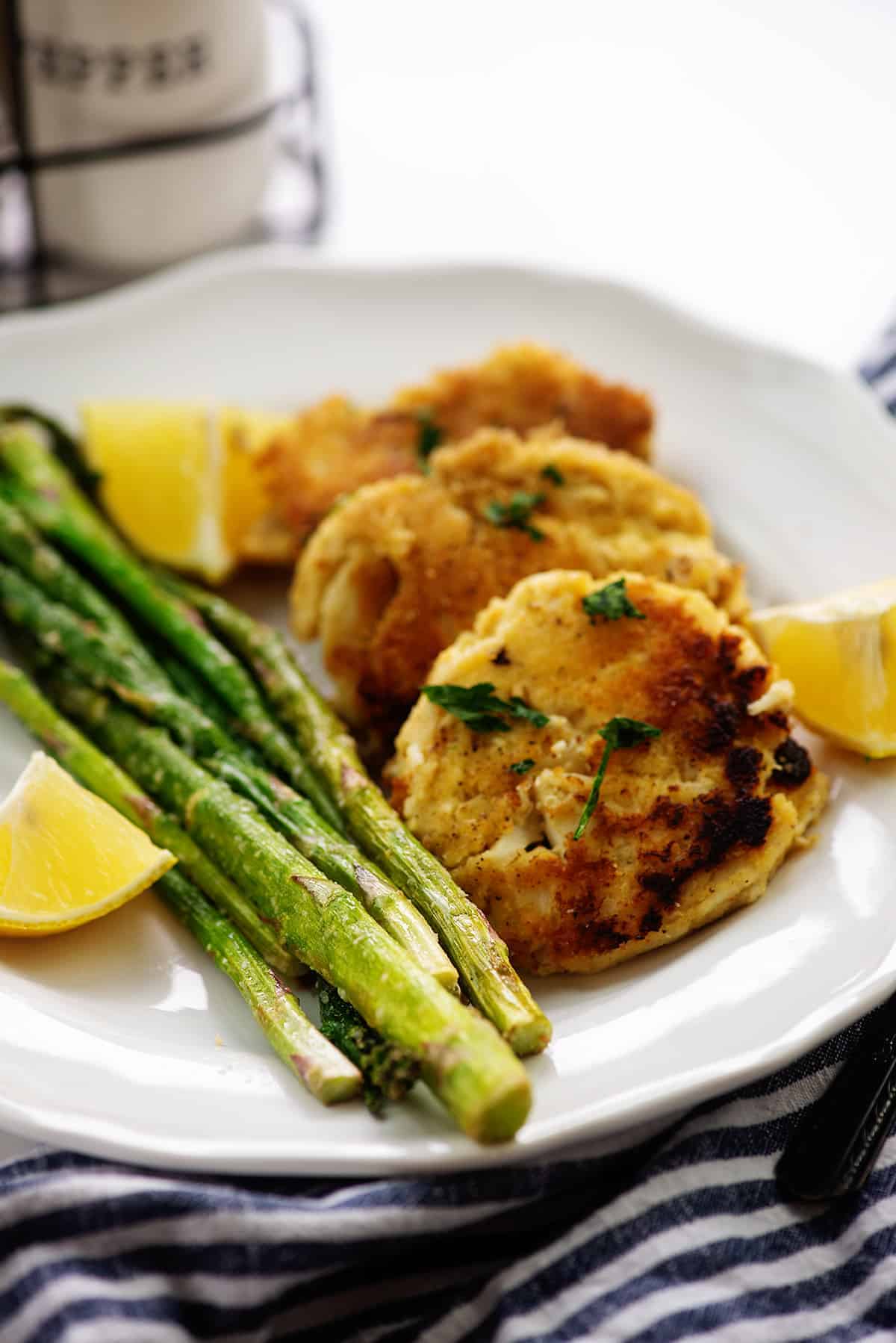 crab cakes on white plate with asparagus.