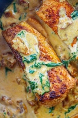 close up view of creamy Tuscan salmon in cream sauce.