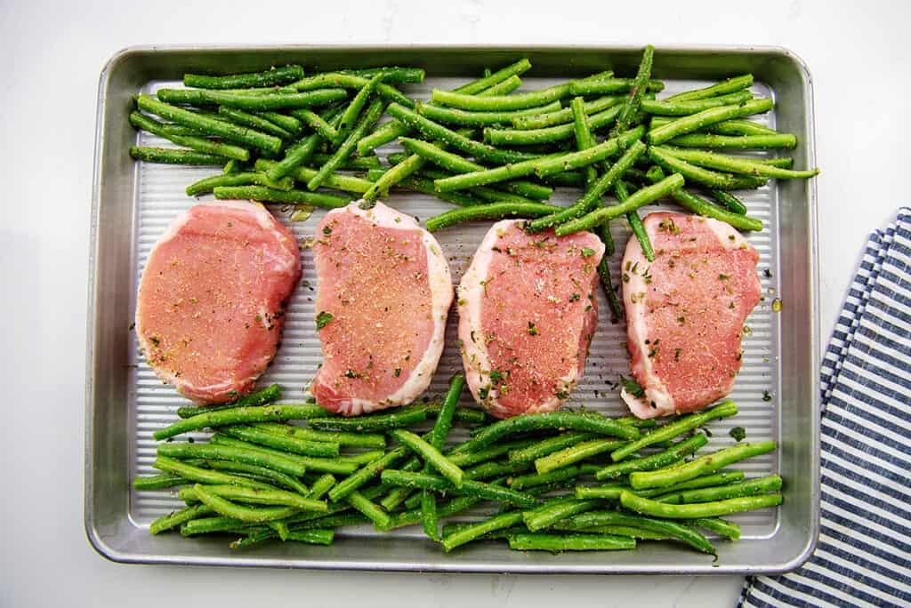 sheet pan loaded with pork chops and green beans