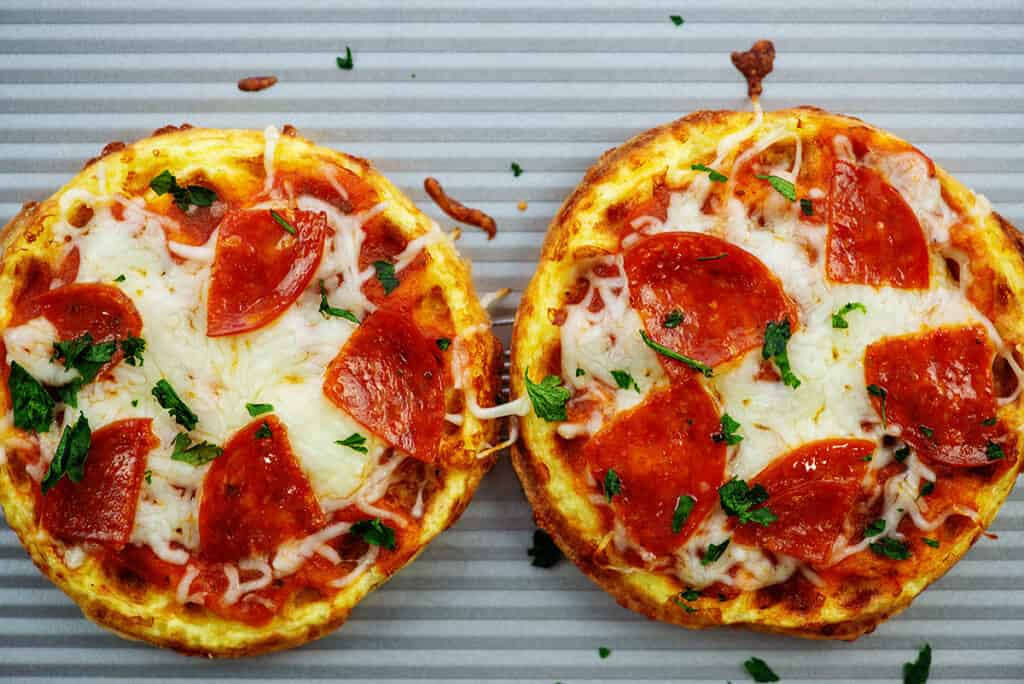 overhead view of pizzas on baking sheet.