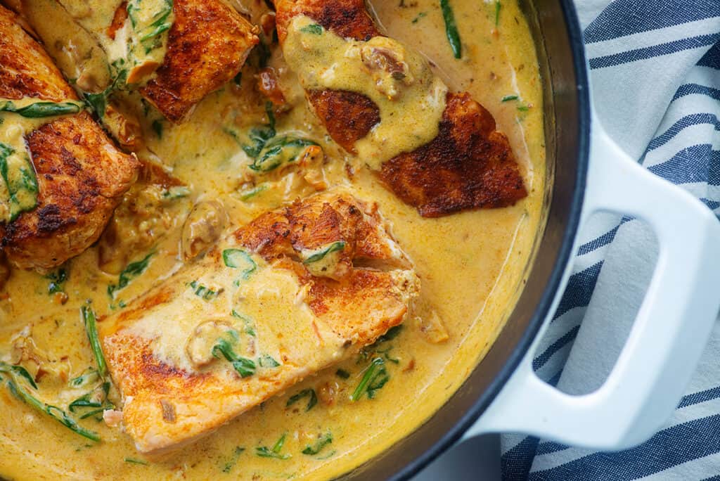 overhead view of salmon in tuscan sauce in skillet.