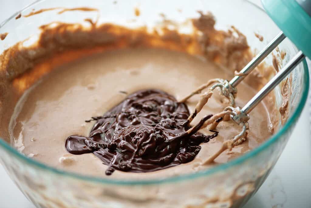 chocolate cheesecake filling with melted chocolate in glass bowl.