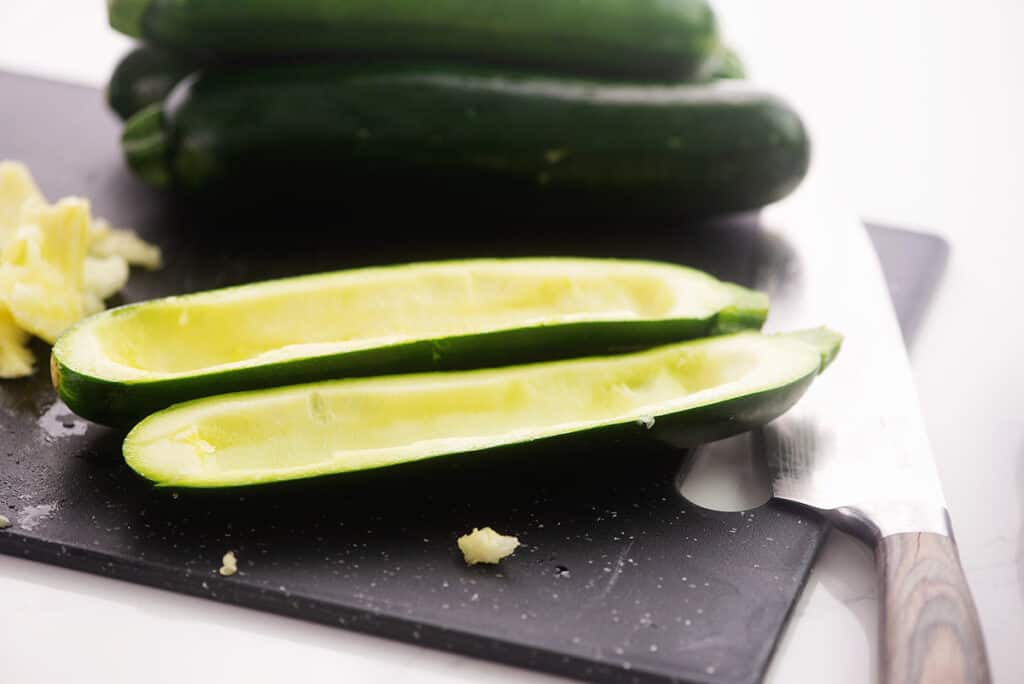 hollowed out zucchini on cutting board.