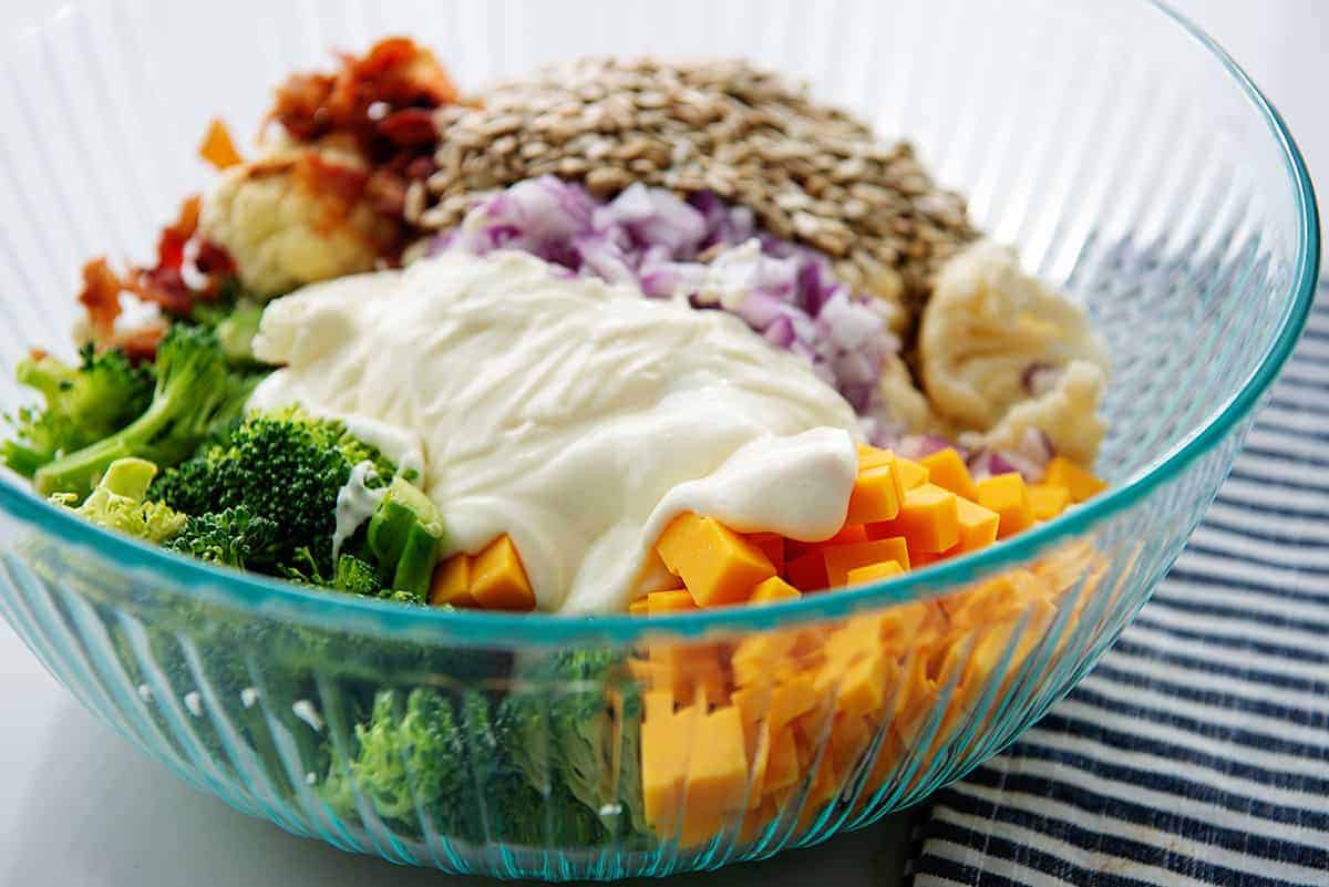 broccoli and cauliflower salad with dressing over the top.