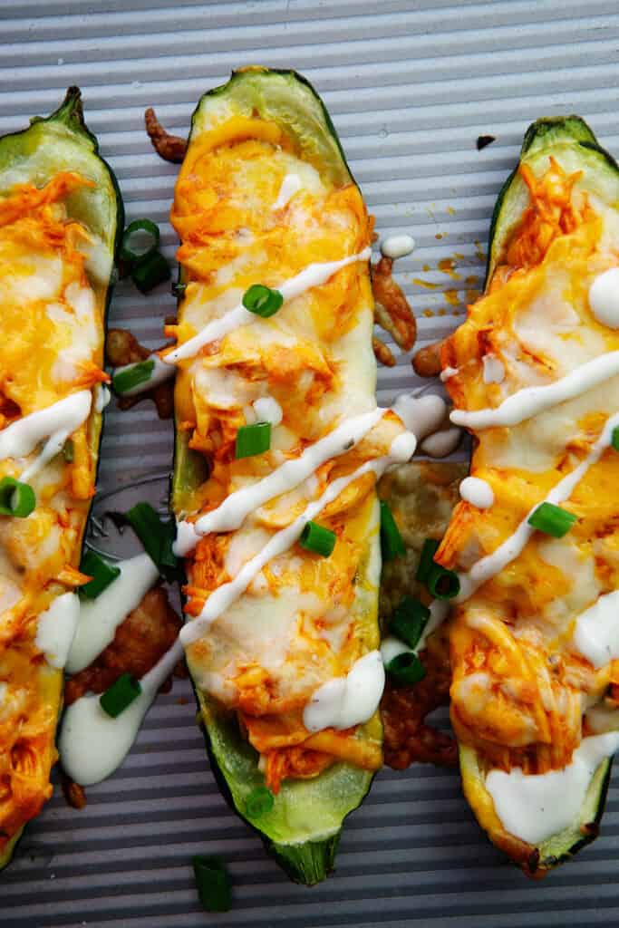 buffalo chicken stuffed zucchini on baking sheet.