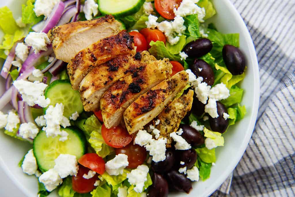 greek chicken salad recipe in white bowl.