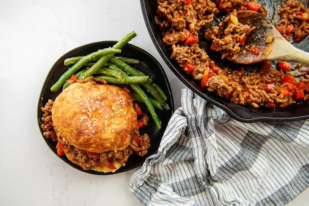 overhead view of sloppy joes on black plate.