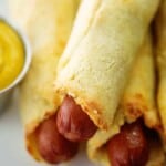 keto pigs in a blanket piled next to mustard.