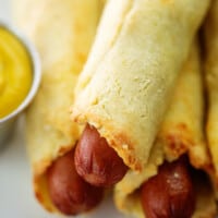 keto pigs in a blanket piled next to mustard.