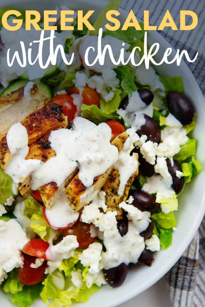 greek salad topped with chicken with text for Pinterest.