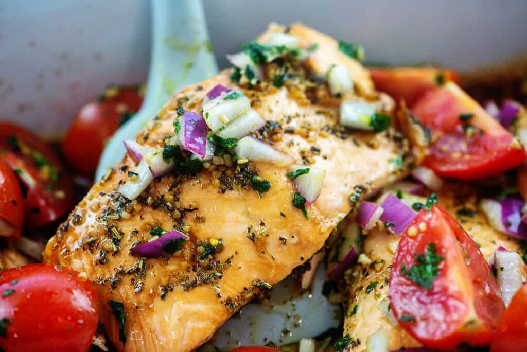 baked salmon with tomatoes and basil on top.